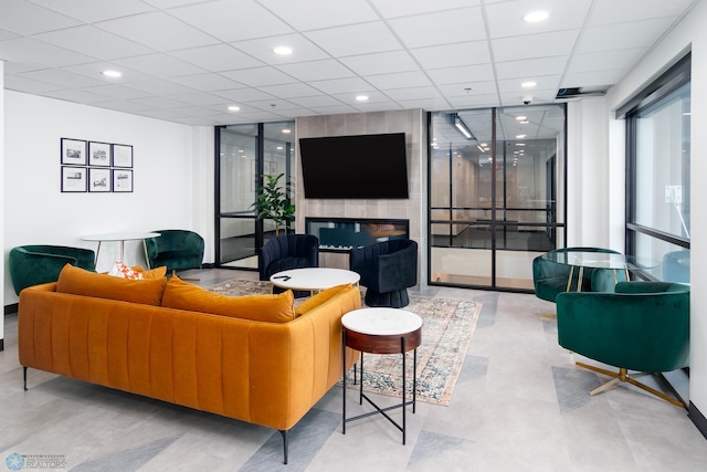 living area featuring a drop ceiling and recessed lighting