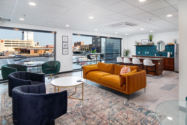 living area with a paneled ceiling, recessed lighting, and a city view