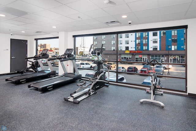 exercise room with baseboards, recessed lighting, visible vents, and a paneled ceiling
