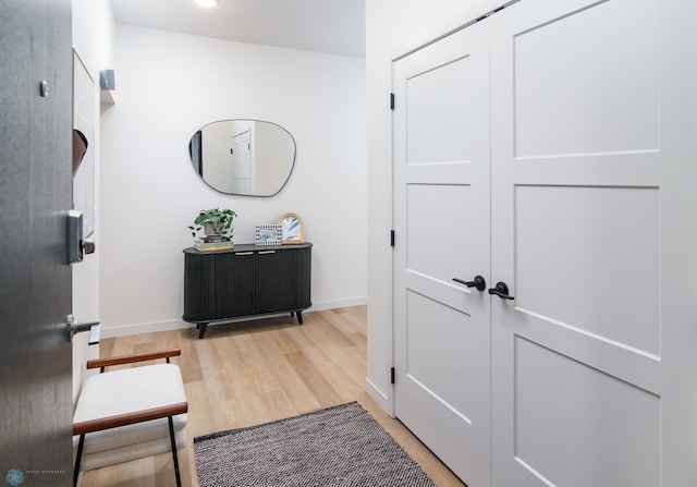 hallway with baseboards and light wood-style flooring