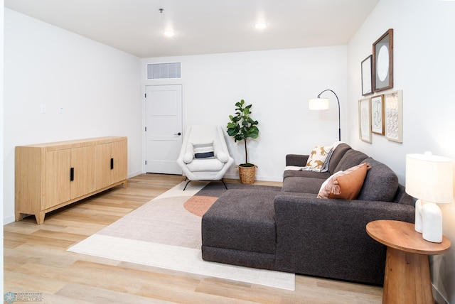 living room with recessed lighting, baseboards, light wood-style floors, and visible vents