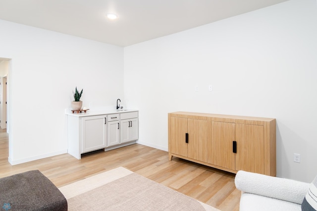sitting room featuring baseboards and light wood-type flooring