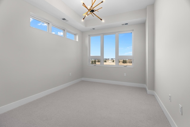 spare room with carpet floors and a notable chandelier