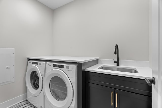 clothes washing area featuring washer and clothes dryer, tile patterned flooring, cabinets, and sink