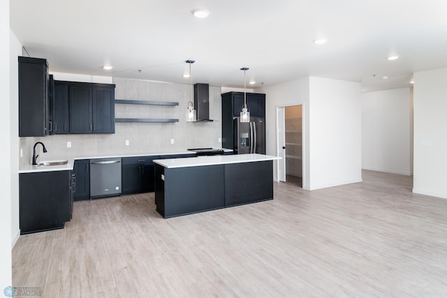 kitchen with backsplash, a center island, sink, appliances with stainless steel finishes, and light hardwood / wood-style floors