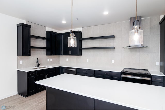 kitchen featuring decorative light fixtures, stainless steel appliances, light hardwood / wood-style floors, sink, and exhaust hood