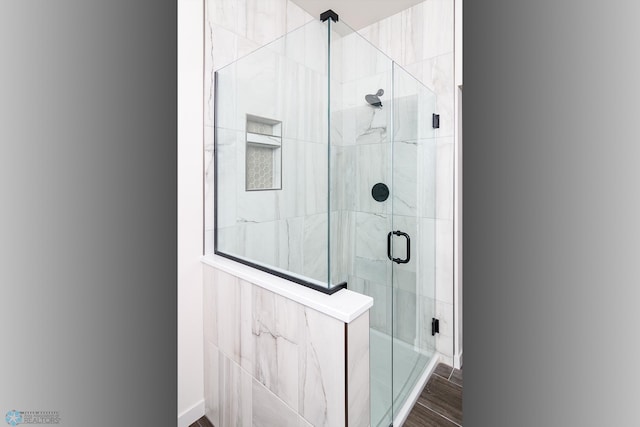 bathroom featuring a shower with door and wood-type flooring