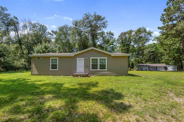 rear view of property featuring a yard