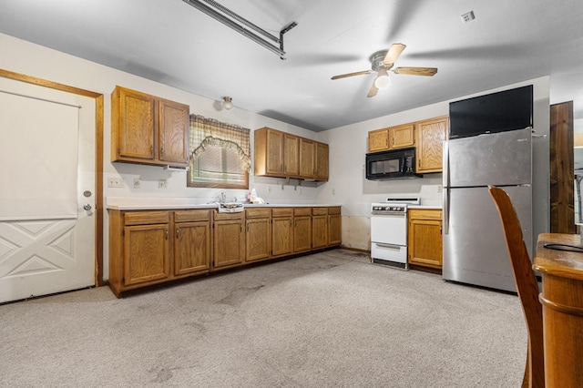 kitchen featuring white range oven, stainless steel fridge, light colored carpet, and ceiling fan