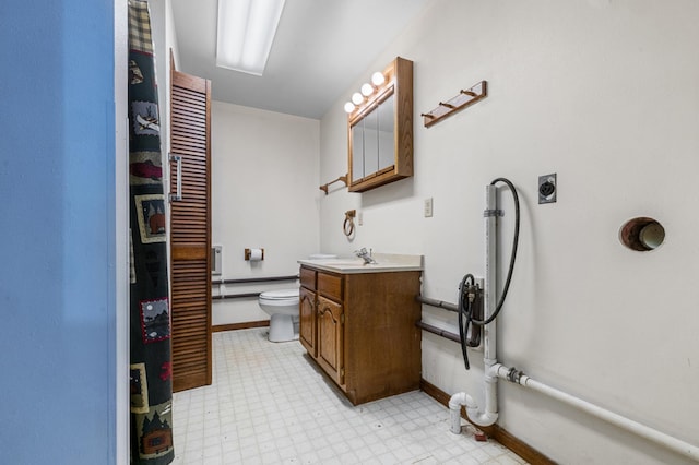 bathroom featuring a baseboard heating unit, vanity, and toilet