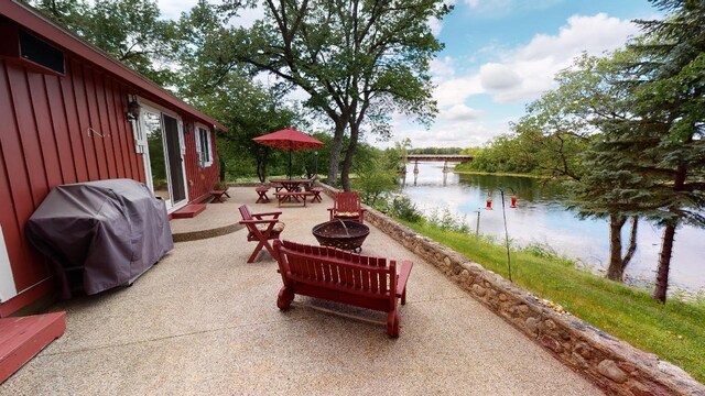 view of patio / terrace featuring a fire pit, grilling area, and a water view