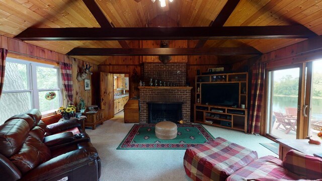 carpeted living room with vaulted ceiling with beams, a brick fireplace, wooden walls, and wood ceiling