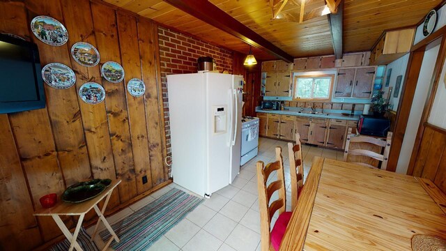 kitchen with light tile patterned flooring, beamed ceiling, white appliances, and wooden ceiling