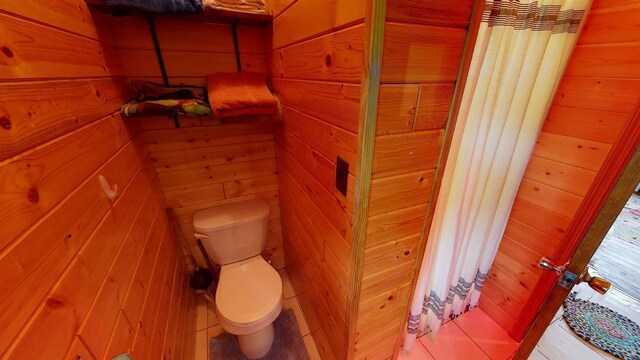 bathroom with wooden walls and toilet