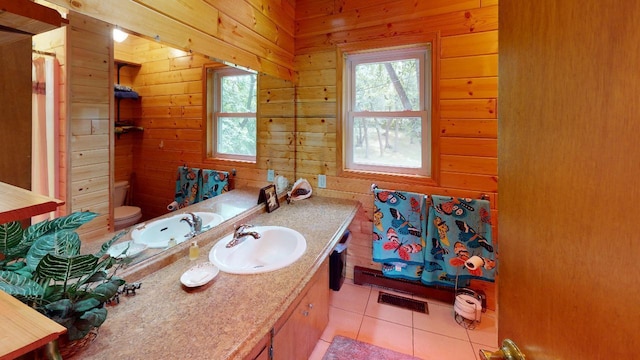 bathroom featuring tile patterned flooring, wood walls, toilet, and vanity