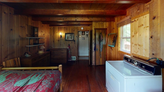 bedroom with beamed ceiling, washer / clothes dryer, wood walls, and dark wood-type flooring