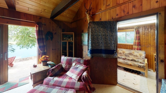 bedroom with vaulted ceiling with beams, wood ceiling, carpet floors, and wood walls