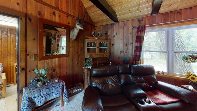 carpeted living room featuring lofted ceiling with beams, wooden walls, and wooden ceiling