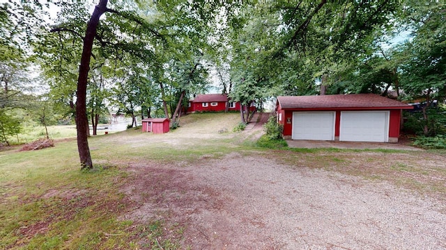 view of yard with a garage and an outbuilding