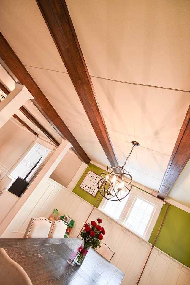 room details featuring beamed ceiling and a chandelier