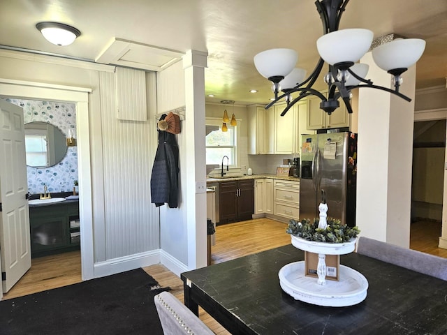 kitchen featuring stainless steel fridge, light hardwood / wood-style floors, ornamental molding, and sink