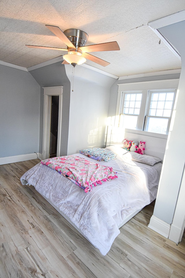 bedroom featuring a textured ceiling, light hardwood / wood-style floors, ceiling fan, and lofted ceiling