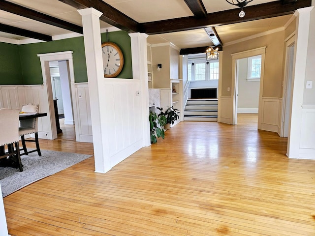 interior space with beam ceiling, light hardwood / wood-style flooring, decorative columns, and ornamental molding