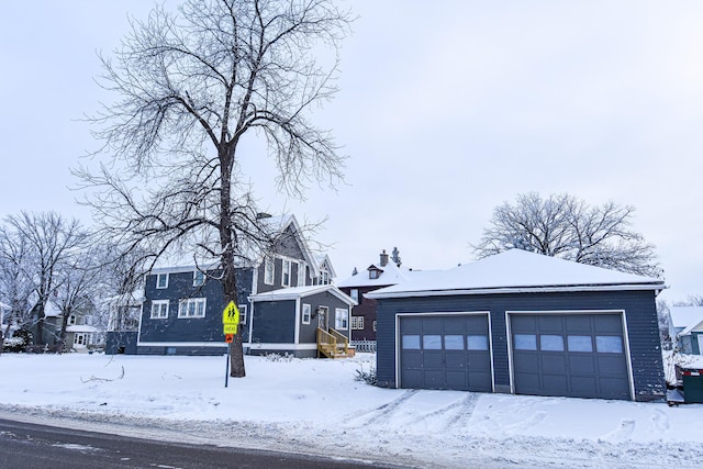 view of front of house with a garage and an outbuilding