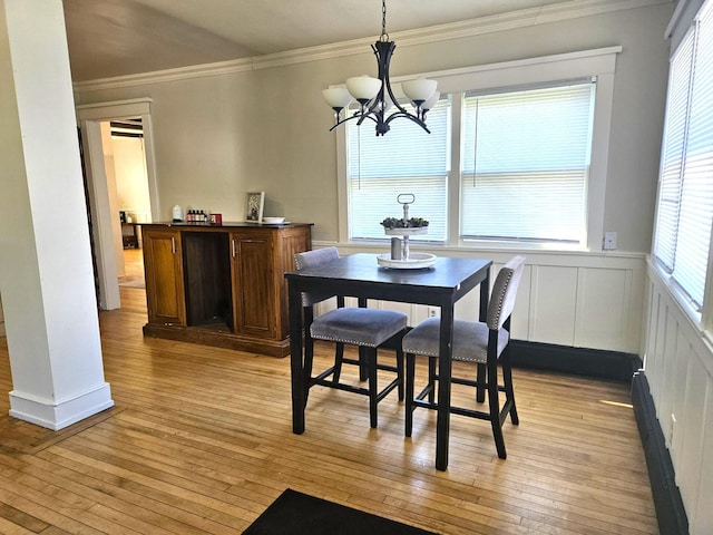 721 Labree Ave N, Thief River Falls, MN 56701 - dining area featuring light wood-style floors, plenty of natural light, crown molding, a chandelier, and a wainscoted wall