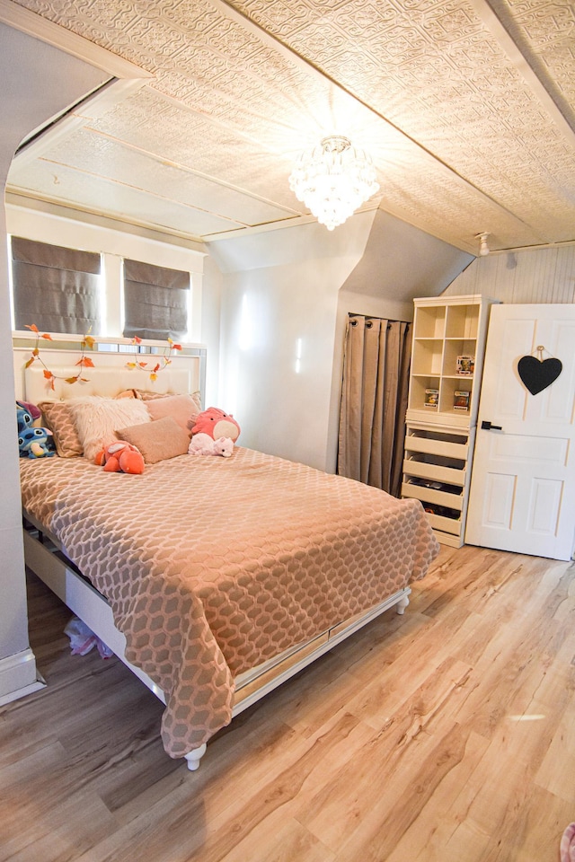 721 Labree Ave N, Thief River Falls, MN 56701 - bedroom with wood finished floors, a chandelier, and vaulted ceiling