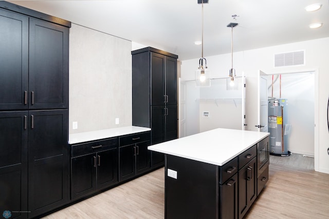 kitchen featuring a center island, decorative light fixtures, light hardwood / wood-style flooring, and electric water heater