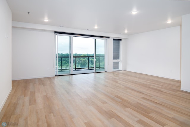 spare room with light wood-type flooring and expansive windows