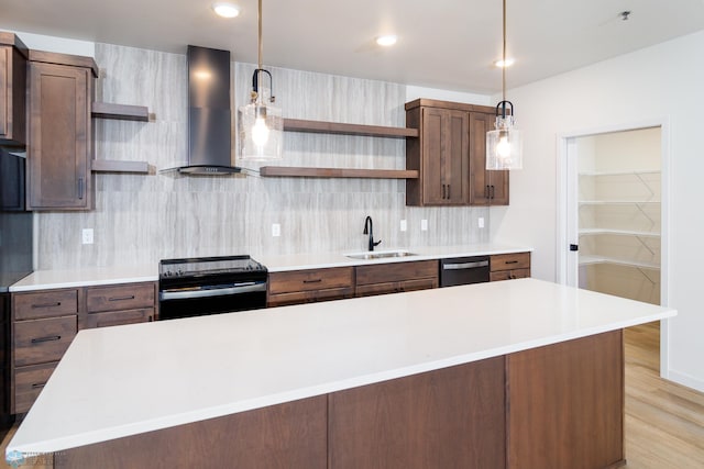 kitchen with tasteful backsplash, sink, wall chimney range hood, pendant lighting, and black electric range oven