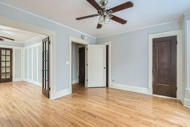 spare room with french doors, crown molding, light wood-type flooring, and ceiling fan