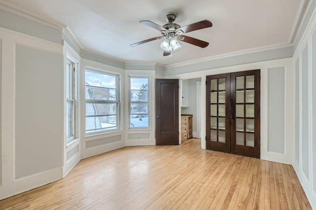 spare room with light hardwood / wood-style floors, french doors, ornamental molding, and ceiling fan