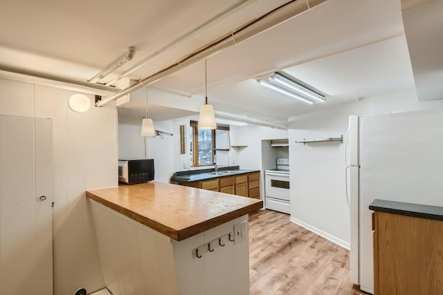 kitchen featuring hanging light fixtures, white appliances, sink, light hardwood / wood-style flooring, and kitchen peninsula