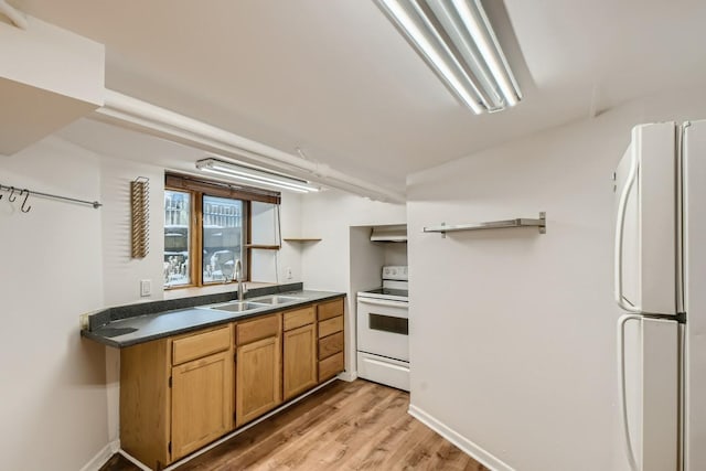 kitchen with light hardwood / wood-style flooring, white appliances, sink, and wall chimney range hood