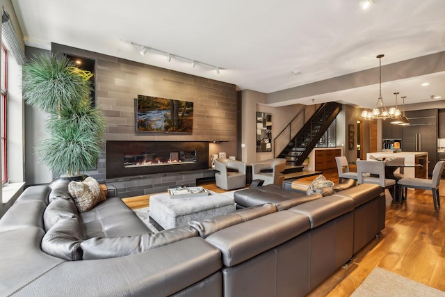 living room with hardwood / wood-style flooring, track lighting, and a notable chandelier