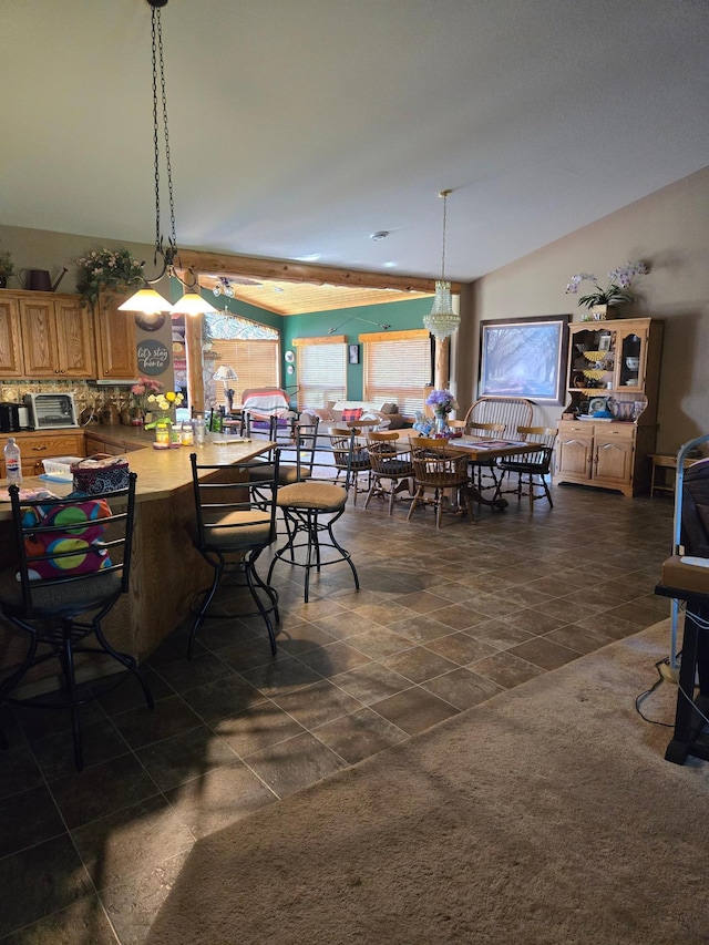 dining area featuring lofted ceiling and dark tile patterned flooring