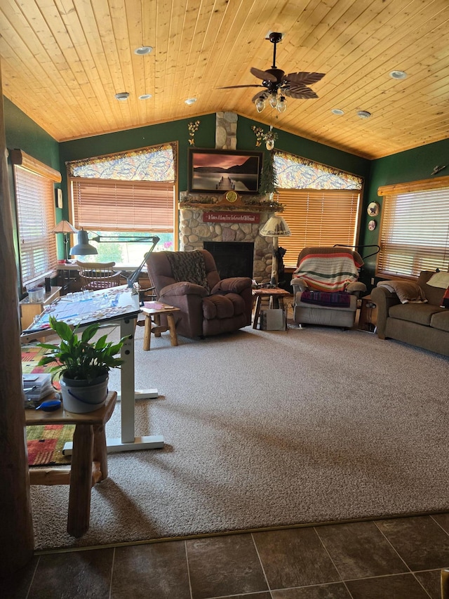 living room featuring vaulted ceiling, a fireplace, dark tile patterned flooring, wooden ceiling, and ceiling fan