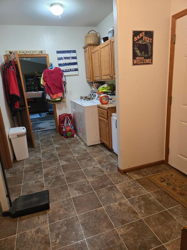 clothes washing area with cabinets, separate washer and dryer, and dark tile patterned flooring