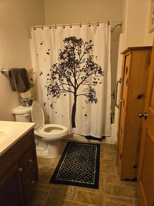 bathroom featuring vanity, toilet, and tile patterned flooring