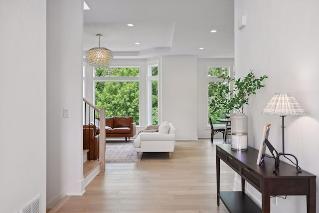 living room with light hardwood / wood-style flooring and a notable chandelier