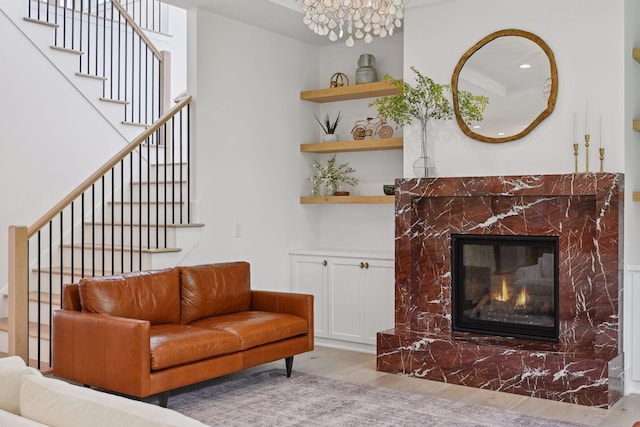 21412 Poate Ct, Rogers, MN 55374 - living room featuring stairway, an inviting chandelier, a fireplace, and wood finished floors