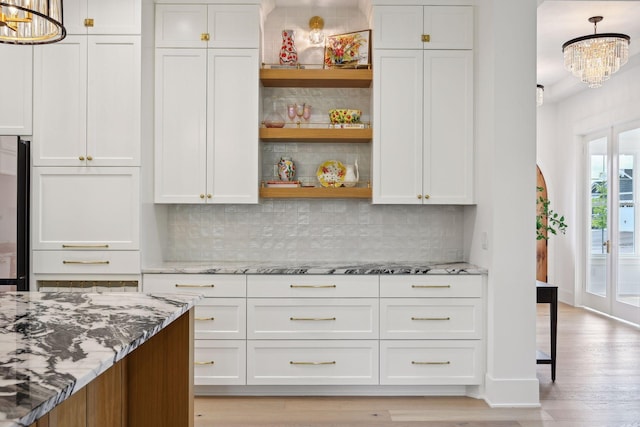 21412 Poate Ct, Rogers, MN 55374 - kitchen with light stone countertops, open shelves, a chandelier, and white cabinets
