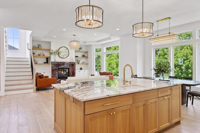 21412 Poate Ct, Rogers, MN 55374 - kitchen featuring a raised ceiling, an inviting chandelier, light wood-style flooring, and a sink