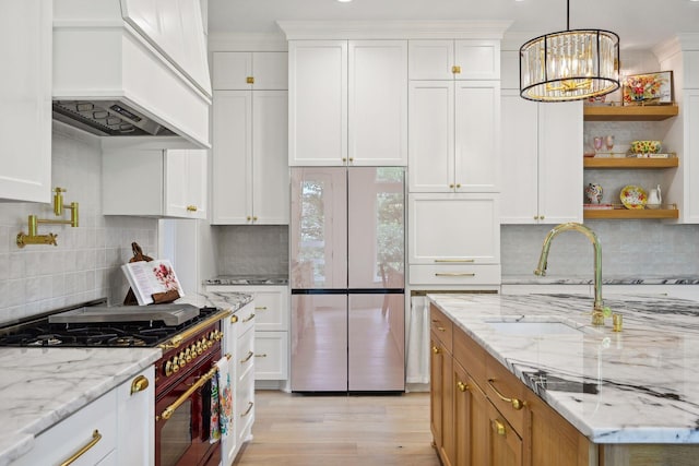 kitchen with white cabinetry, high quality appliances, tasteful backsplash, and custom range hood