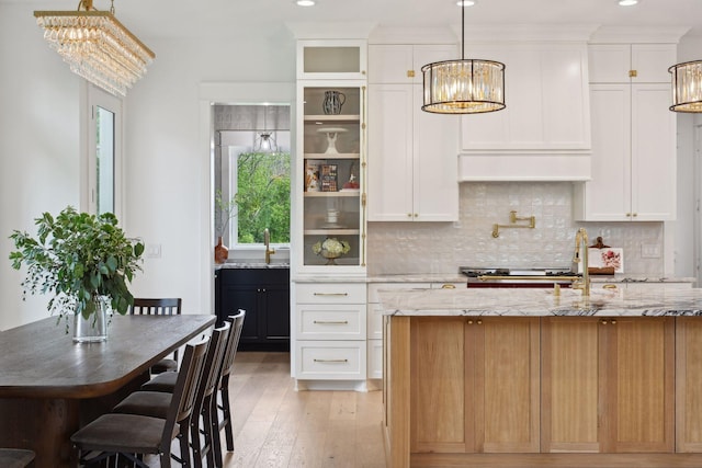 21412 Poate Ct, Rogers, MN 55374 - kitchen featuring light wood finished floors, decorative backsplash, an inviting chandelier, and plenty of natural light