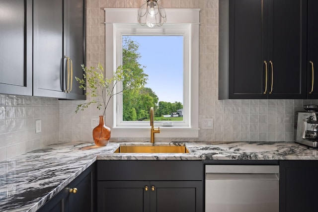 kitchen with sink, decorative backsplash, light stone countertops, and a wealth of natural light