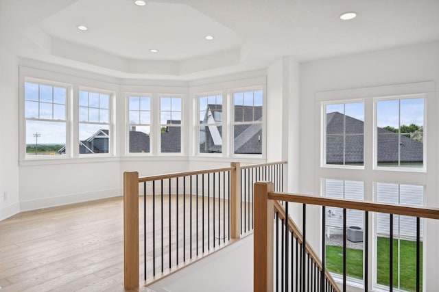 corridor featuring light hardwood / wood-style floors and a raised ceiling